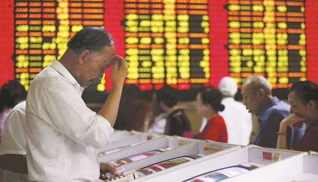 Investors look at computer screens showing stock information at a brokerage house in Shanghai. The Composite index closed up 5.6% to 2,961.28 points yesterday.