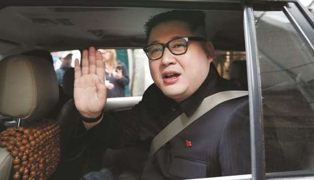 Howard X leaves the La Paix Hotel in a car while escorted by police, in Hanoi yesterday.