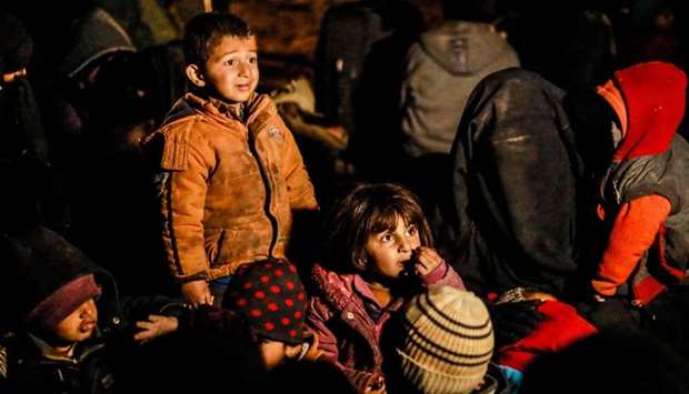 Women and children evacuated from the Islamic State (IS) group's embattled holdout of Baghouz wait in a zone held by the US-backed Syrian Democratic Forces (SDF) during an operation to expel IS jihadists from the area, in the eastern Syrian province of Deir Ezzor