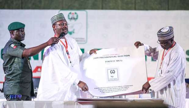 Nigeriau2019s Independent National Electoral Commission (INEC) chairman Mahmood Yakubu displays vote result sheets in Abuja yesterday during an announcement on the presidential elections.