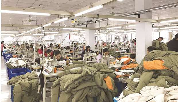 Workers make Orolay jackets at the companyu2019s factory complex in Jiaxing, Zhejiang province. Factory activity in China is expected to have contracted for the third month in a row in February, a Reuters poll showed, adding to evidence of a further slowdown in the economy in the first quarter.