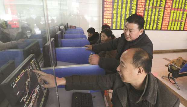 Investors talk as they look at a computer screen showing stock information at a brokerage house in China. While margin debt in China is much lower today than when it helped precipitate a market collapse in 2015, investors are boosting leverage quickly as they chase a rally that added more than $1tn to stock values since the start of 2019.