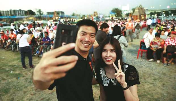 Future Forward Party leader Thanathorn Juangroongruangkit takes a selfie with his supporter during his campaign rally in Bangkok yesterday.