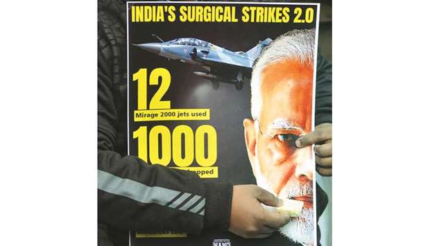 A supporter offers sweets to a poster displaying Prime Minister Narendra Modiu2019s portrait in New Delhi yesterday.