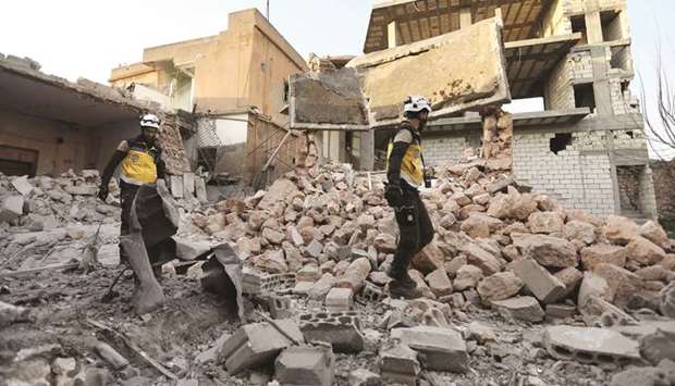 Members of the Syrian Civil Defence (also known as u201cThe White Helmetsu201d) check the rubble at a building that was hit by shelling in the town of Saraqib in the mostly rebel-held northern Idlib province, yesterday.