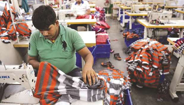 Indian men work at a garment factory in Ludhiana. Indiau2019s economy appeared to be losing momentum in the approach to a general election that must be held by May, as a Reuters survey of economists forecast that growth slipped to 6.9% annually in the October-December quarter.