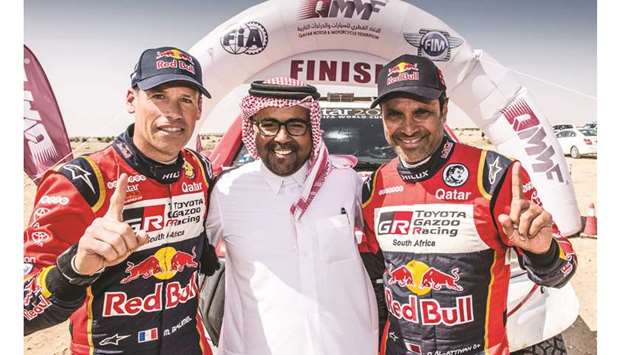 Nasser Saleh al-Attiyah (right) and co-driver Matthieu Baumel (left) celebrate their Qatar Cross-Country Rally win with QMMF president Abdulrahman al-Mannai.