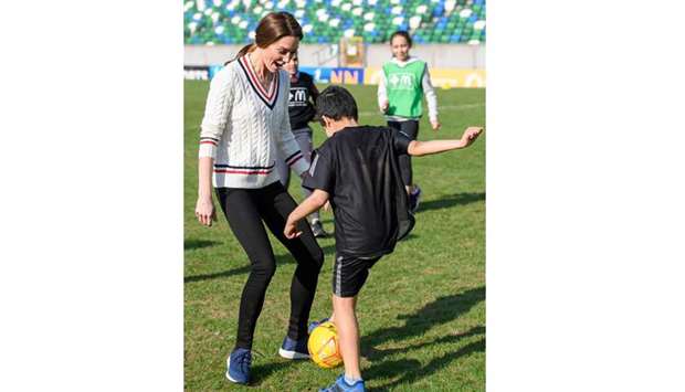 Catherine, Duchess of Cambridge, plays football with children during a visit to the Irish Football Association in Belfast, Northern Ireland.