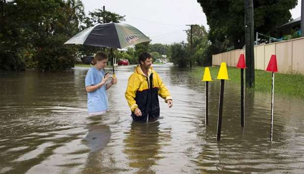 Local residents stand in floodwaters near Hermit Park, Townsville