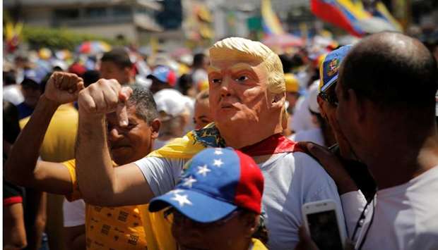 A man wearing a mask of US President Donald Trump gestures during a rally against Venezuelan President Nicolas Maduro's government in Caracas