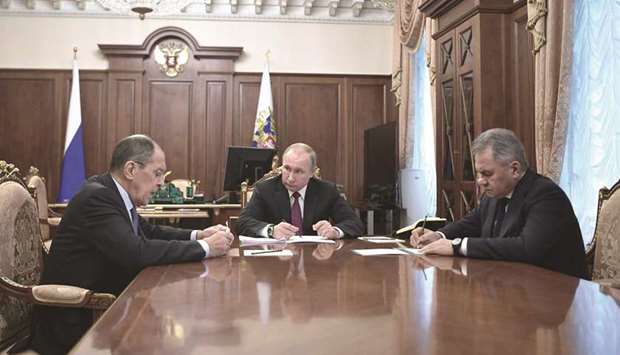 Putin with ministers Lavrov (left) and Shoigu in Moscow.
