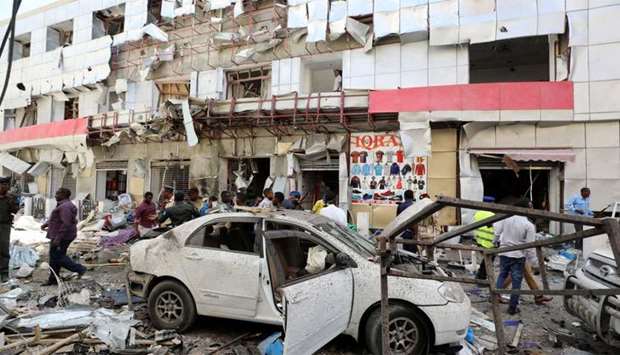 Somali security forces walk through the scene of an explosion in Mogadishu