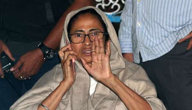 Mamata Banerjee speaks on her mobile phone as she sits in a protest against an attempted raid by India's CBI officials on the residence of Kolkata police commissioner, in Kolkata