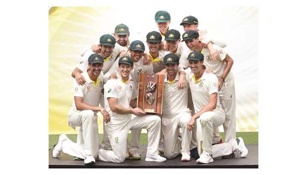 Australian players pose with the trophy after defeating Sri Lanka in the second Test at the Manuka Oval Cricket Ground in Canberra yesterday. (AFP)
