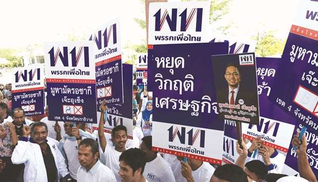 Supporters of Pheu Thai Party gather outside as their party candidates for members of parliament for Narathiwat province arrive for registration with the election commission yesterday in southern Thailand.