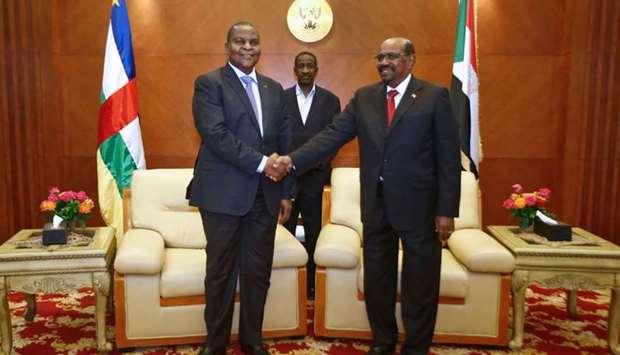 Central African president Faustin-Archange Touadera (L) and Sudanese President Omar al-Bashir (R) shake hands during the inking of a peace deal between the government of the Central African Republic and 14 armed groups in Khartoum