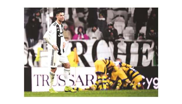 Juventusu2019 Portuguese forward Cristiano Ronaldo (left) is dejected as Parma players celebrate after scoring a last second equaliser during the Serie A match. (AFP)