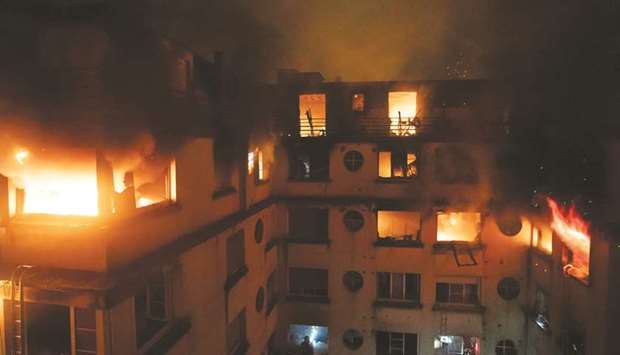 This handout picture taken and released by the Paris firefighters brigade (BSPP) shows the fire in a building in Erlanger street, in the 16th arrondissement in Paris.