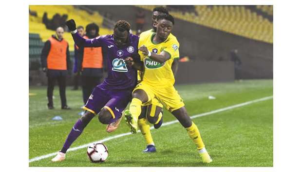 Toulouseu2019s Guinean defender Issiaga Sylla (left) fights for the ball with Nantesu2019 Belgian forward Anthony Limbombe during the French Cup round of 16 match at the La Beaujoire stadium in Nantes, western France on Tuesday night. (AFP)