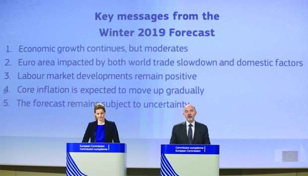European Commissioner for Economic and Financial Affairs Pierre Moscovici (right) presents the EU winter economic forecasts during a news conference at the EU Commission headquarters in Brussels