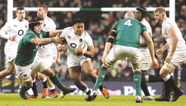 Englandu2019s centre Manu Tuilagi (centre) runs with the ball during the Six Nations match against Ireland at the Aviva Stadium in Dublin on February 2. (AFP)