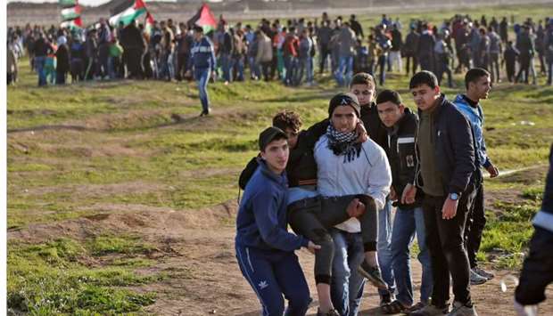 Palestinian demonstrators evacuate a wounded comrade during a demonstration near the fence along the border with Israel, east of Gaza City