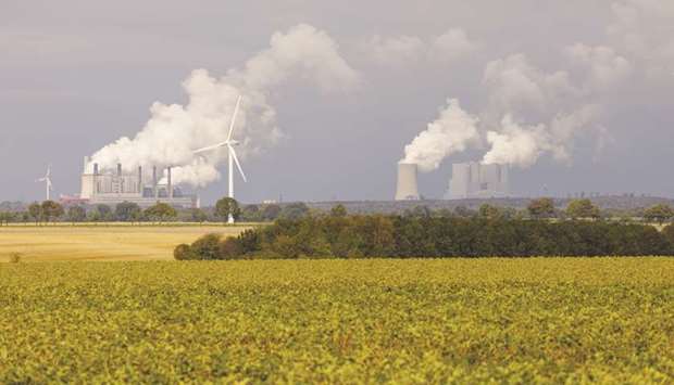 Smoke billows on the horizon from Frimmersdorf, left, and Neurath coal-powered plants, operated by RWE AG, in Hambach, Germany. The German coal commission has set 2038 as the deadline for reaching zero coal.