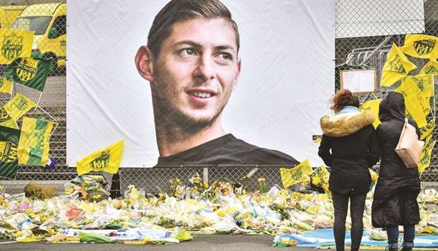 Nantes supporters look at yellow flowers displayed in front of the portrait of Argentinian forward Emiliano Sala at the Beaujoire stadium in Nantes, yesterday. The club Nantes said it was retiring the jersey with Salau2019s number 9. (AFP)