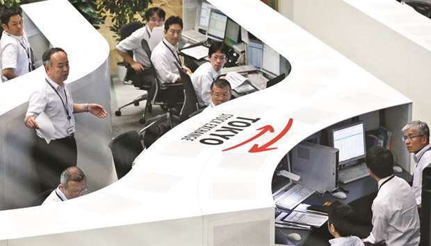 Employees work at the Tokyo Stock Exchange. The Nikkei 225 closed down 2.0% to 20,333.17 points yesterday.