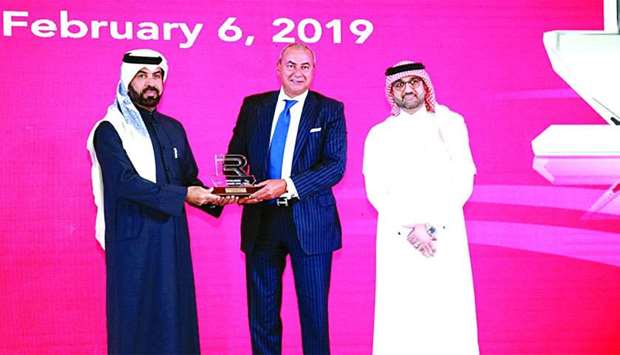 QIB Group CEO Bassel Gamal receiving the award from QSE CEO Rashid bin Ali al-Mansoori.rnrn