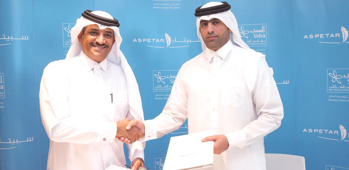 Dr Abdulla al-Kaabi and Dr Khalifa al-Kuwari shake hands after signing the agreement.
