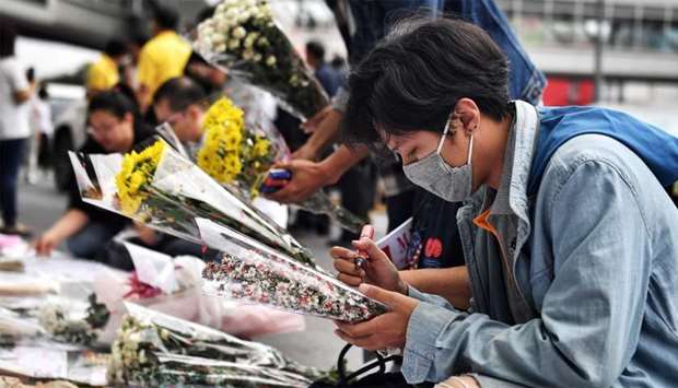 Mourners lay flowers at the Terminal 21 shopping mall, where a mass shooting took place, in the Thai northeastern city of Nakhon Ratchasima