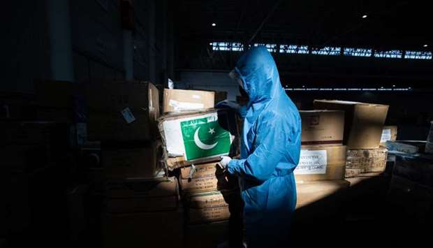This photo taken on February 4, 2020 shows a staff member carrying a box of medical supplies from Pakistan at a warehouse of an exhibition centre which has been converted into a makeshift hospital in Wuhan, the epicentre of the new coronavirus outbreak, in China's central Hubei province.