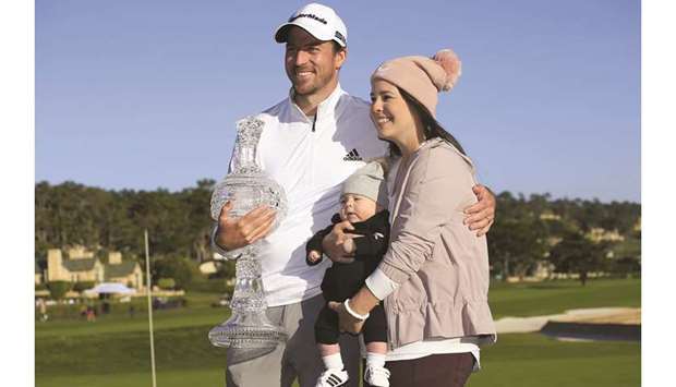 Nick Taylor of Canada poses his wife Andie and son Charlie after winning the Pebble Beach Pro-Am in California on Sunday. (AFP)