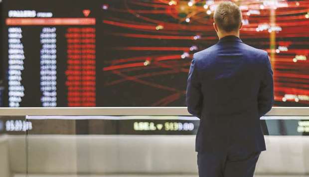 An employee views an FTSE share index board in the atrium of the London Stock Exchange Group offices (file). The FTSE gave up 0.3% to close at 7,446.88 points yesterday.