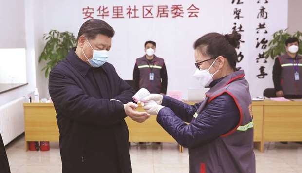 Chinese President Xi Jinping wearing a protective facemask as a health official checks his body temperature during an inspection of the novel coronavirus pneumonia prevention and control work at the Anhuali Community in Beijing.