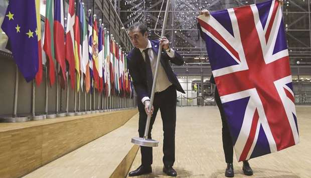 EU Council staff members remove the United Kingdomu2019s flag from the European Council building in Brussels.