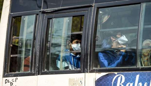 Indian nationals are transported in a bus out of the Indira Gandhi International Airport following their evacuation from the Chinese city of Wuhan, in New Delhi