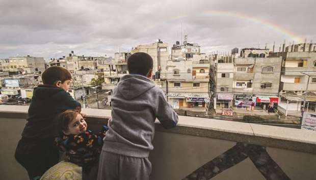 Childrens looks at a rainbow in the sky above Rafah on a rainy day at sunset in the southern Gaza Strip yesterday.