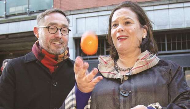 Sinn Fein party leader Mary Lou McDonald throws oranges in the air as she stops at a fruit traderu2019s stall during a walkabout in the centre of Dublin, Ireland, yesterday.