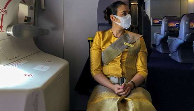 A flight attendant wearing a protective face mask is pictured during a flight from Sydney to Bangkok