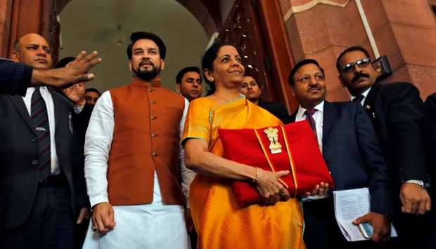 India's Finance Minister Nirmala Sitharaman is flanked by junior Finance Minister Anurag Thakur as she arrives to present the budget in Parliament in New Delhi,