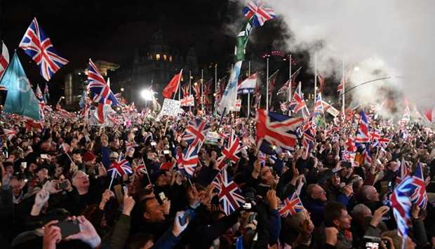 Brexit supporters wave Union flags as the time reaches 11 O'Clock, in Parliament Square, venue for the Leave Means Leave Brexit Celebration in central London