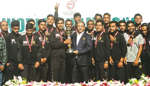 Bangladeshu2019s Under-19 captain Akbar Ali poses with his teammates, ICC Under-19 World Cup trophy and Bangladehu2019s Cricket Board president Nazmul Hasan Papon (centre right) during a reception ceremony at the Sher-e-Bangla National Cricket Stadium yesterday. (AFP)