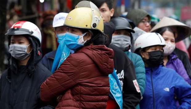 Vietnamese residents line up to buy protective mask at a shop in Hanoi, Vietnam