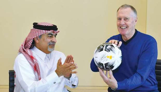 Sir Geoff Hurst holds a football after signing it on Wednesday in the presence of Qatar Olympic and Sports Museum director Abdulla Yousuf al-Mulla.