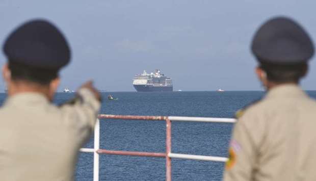 The Westerdam cruise ship is seen past Cambodian policemen as it approaches port in Sihanoukville, Cambodiau2019s southern coast yesterday, where the liner had received permission to dock after been refused entry at other Asian ports due to fears of the COVID-19 coronavirus.  Japan, Guam, the Philippines, Taiwan and Thailand all refused to allow the ship to dock, despite operator Holland America insisting there were no cases of the deadly disease on board.