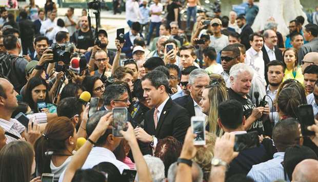 Venezuelan opposition leader Juan Guaido is surrounded by supporters and journalists as he arrives for a plenary session of the National Assembly at Bolivar square in Caracas on Wednesday.