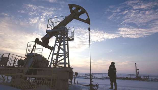 A worker inspects a pumping jack during oil drilling operations in an oilfield operated by Bashneft in Russia (file). A growing oil glut in Russia and the promise of a flood of dollars from the sale of a leading bank are strengthening the case for Russia to cut oil output in tandem with Opec, according to sources.