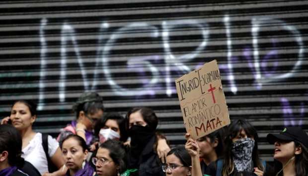 :A demonstrator holds up a placard that reads ,Ingrid Escamilla. Romantic Love Kills, at a protest against gender-based violence in downtown of Mexico City, Mexico